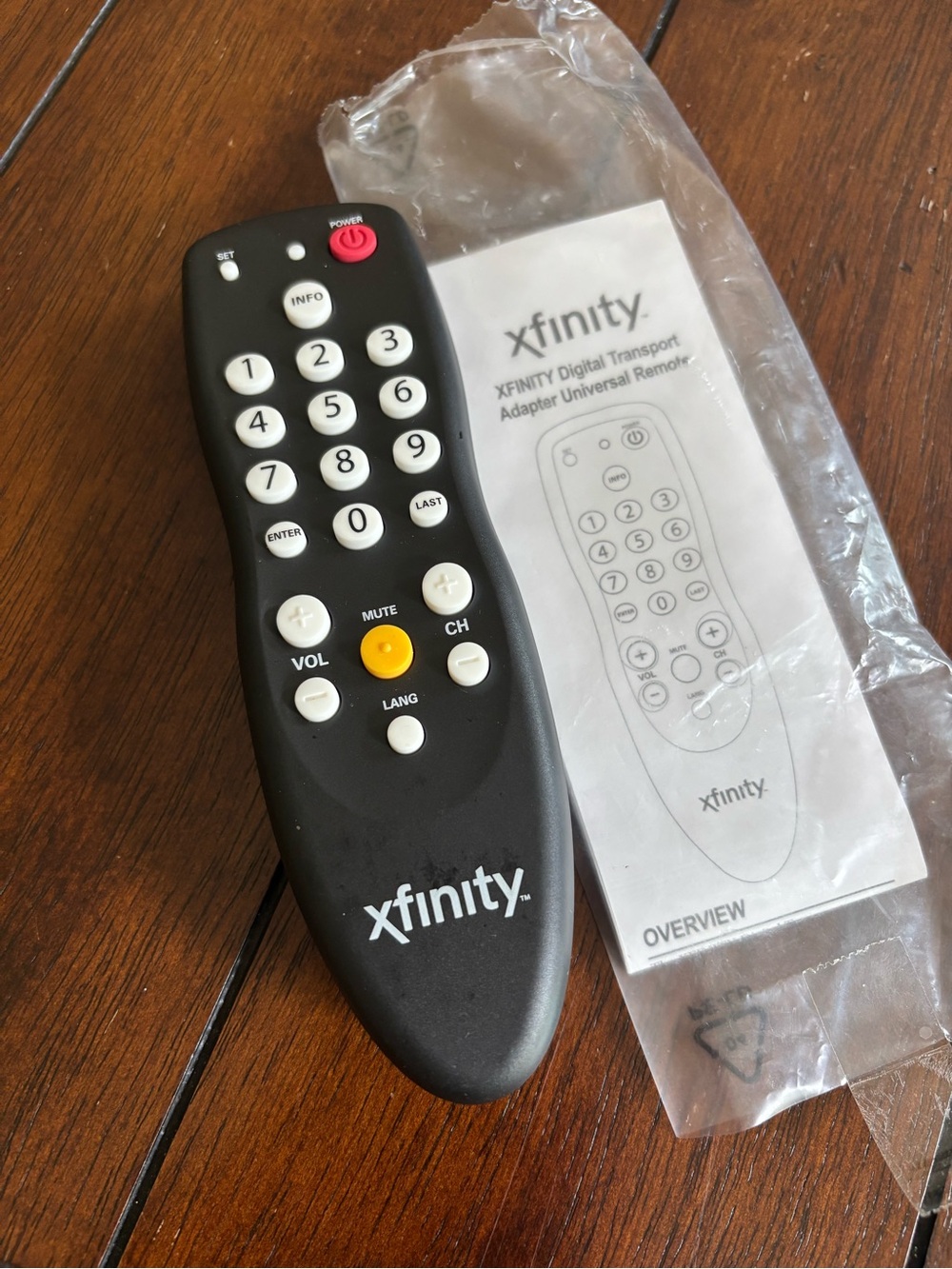 Xfinity Black Universal Remote with White Buttons and its manual